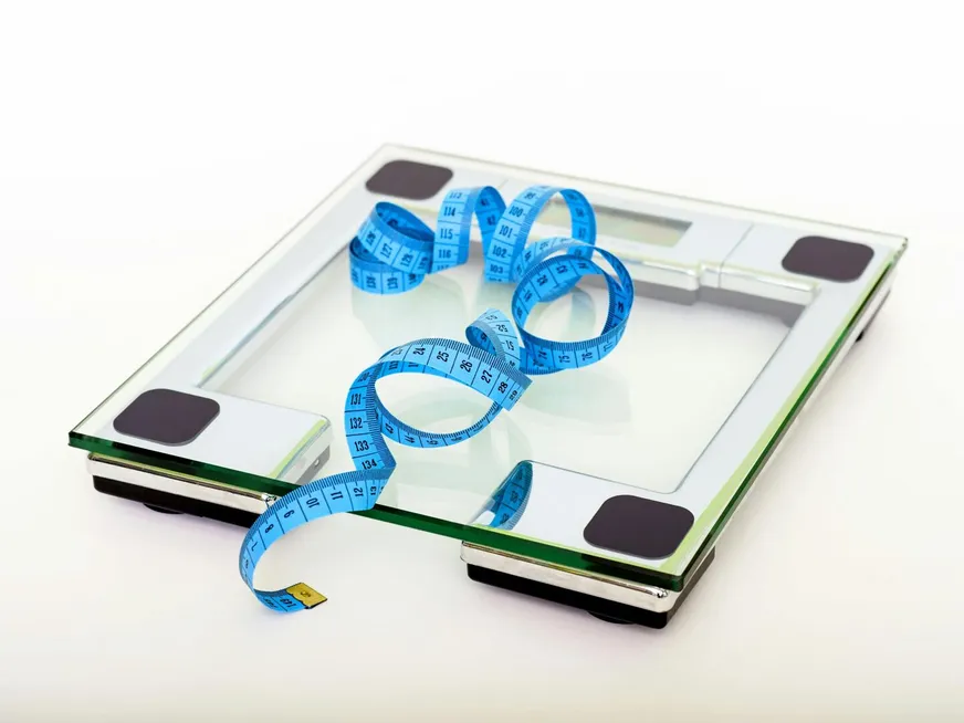 A digital glass weighing scale with a blue