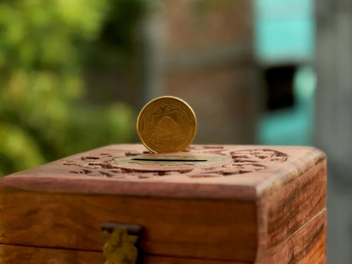 Close-up of a golden coin resting on a carved