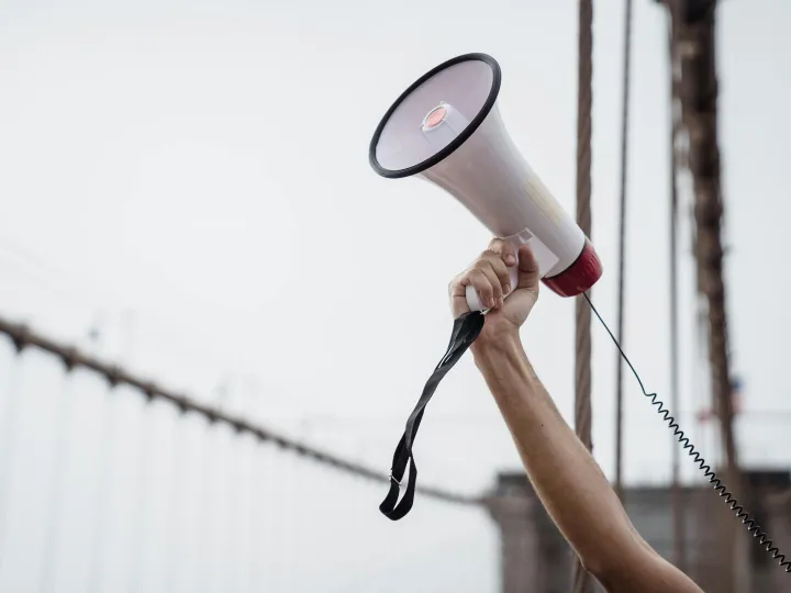 A hand holding a megaphone, symbolizing protest