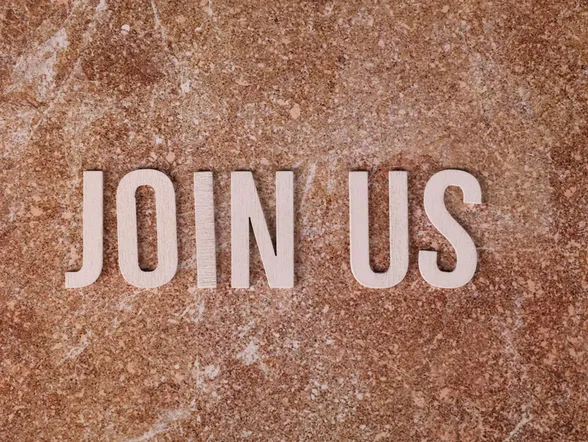 Wooden letters spelling 'Join Us' on a brown