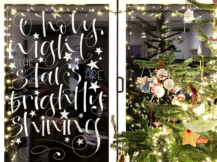 Hand painted Christmas window lettering reading Holy night all is bright