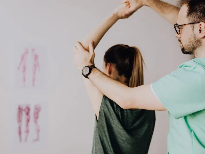 Physiotherapist assessing a client's arm and shoulder