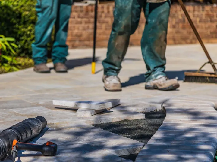 Landscapers laying stone paving for a garden patio