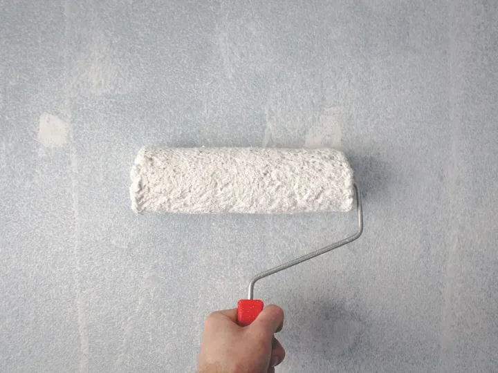 Decorator applying paint to a wall with a roller