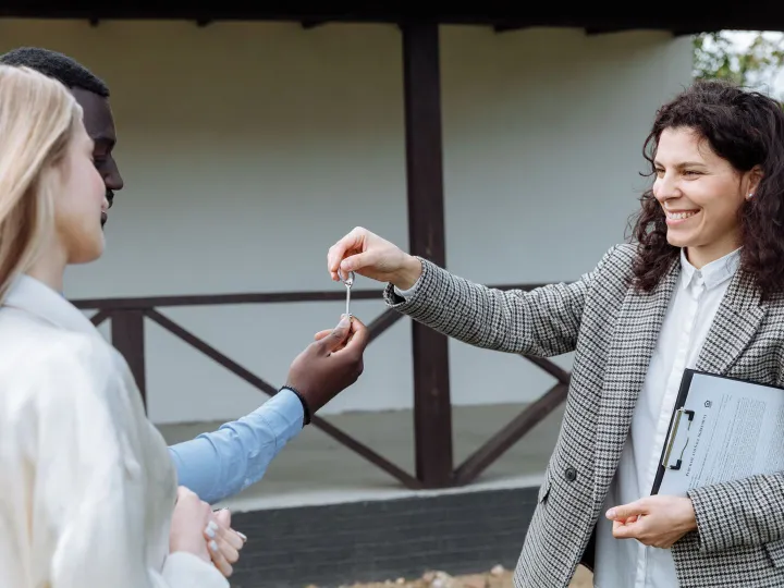 An estate agent handing a set of house keys to a client