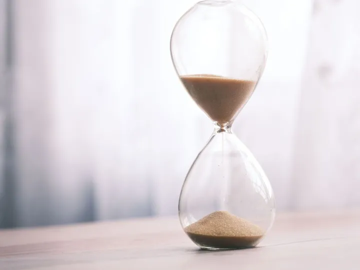 Minimalist hourglass filled with sand symbolizing