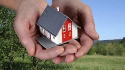 Hands holding a toy house