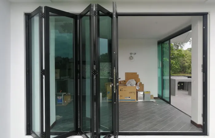 A black bifold door on the patio