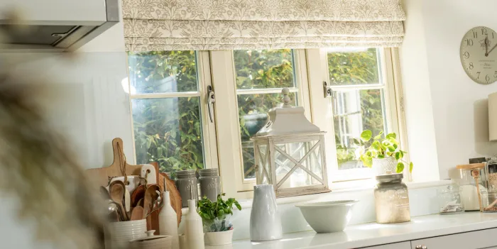 Patterned roman blinds in cream and white kitchen