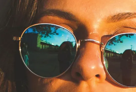 Woman with gold-rimmed reflective sunglasses