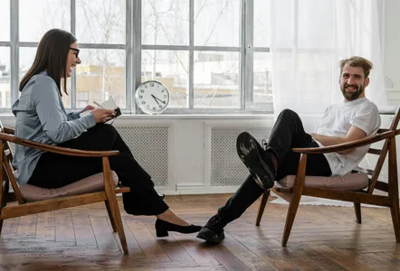 2 Women Sitting on Brown Wooden Chair