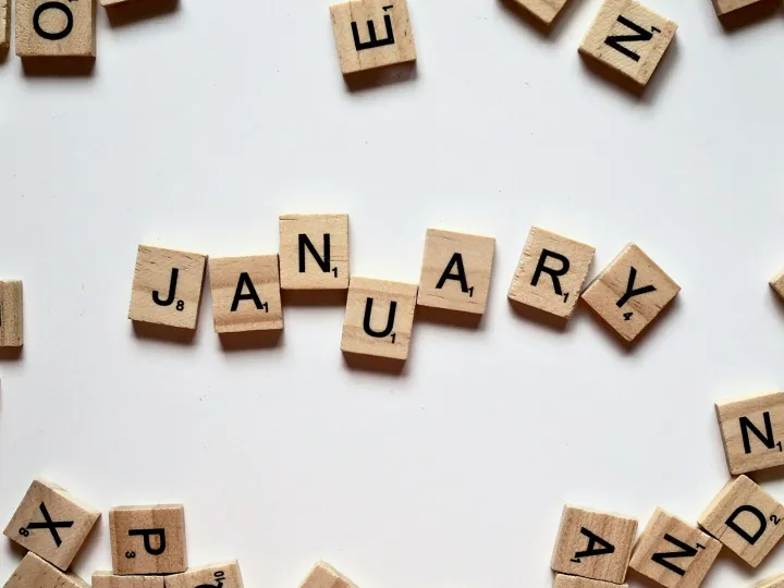 Close-up of Scrabble tiles spelling 'January' on a white surface, perfect for winter or new year themes.