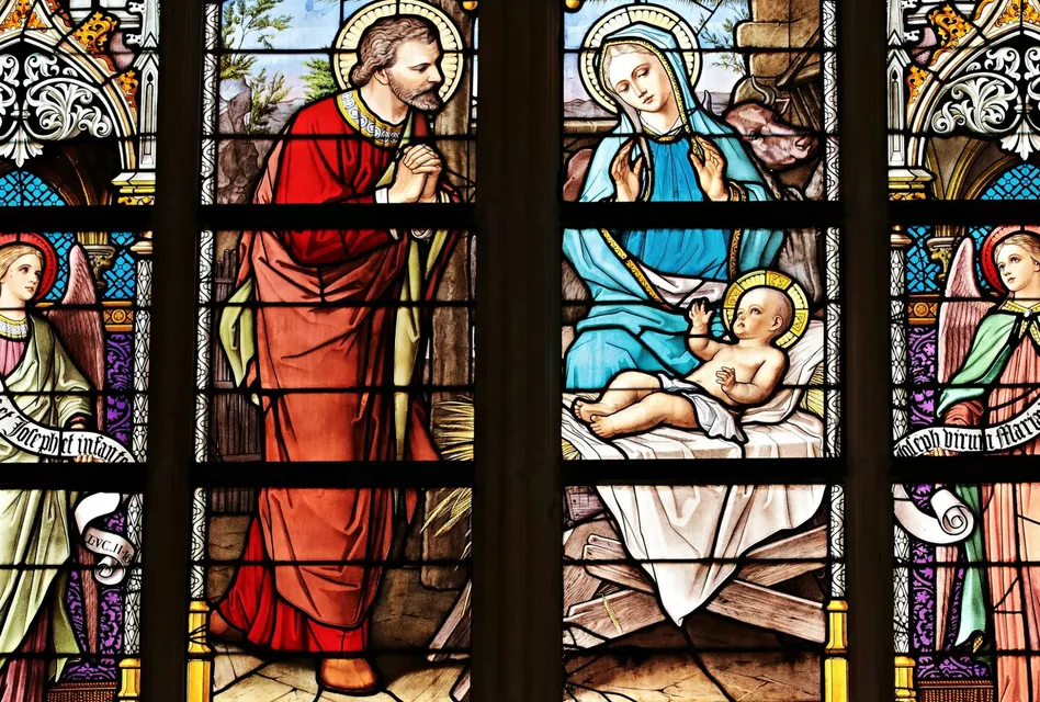 Vibrant stained glass window illustrating a biblical nativity scene with vivid colors in a church setting.