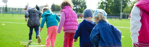Children enjoy an outdoor activity on a grassy