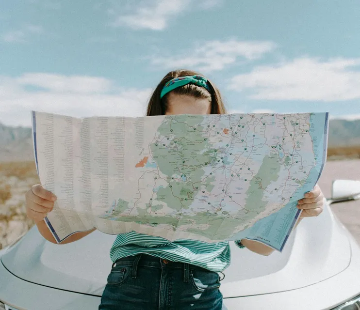 A woman holds a map while traveling through the