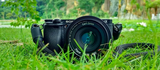 Camera with Carl Zeiss lens on grass, surrounded