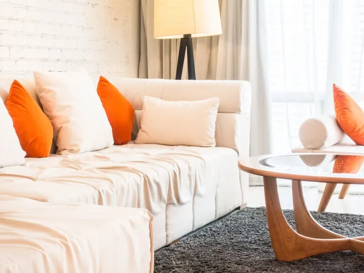 Large couch with cushions and glass table