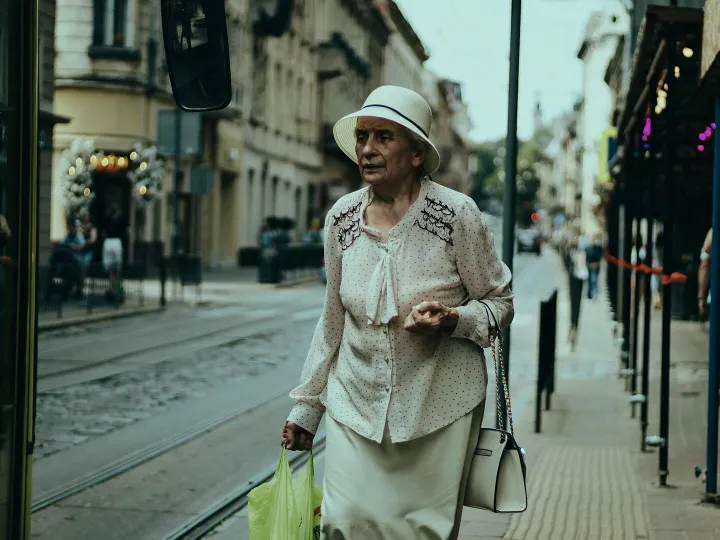 Senior woman in elegant attire walking down a