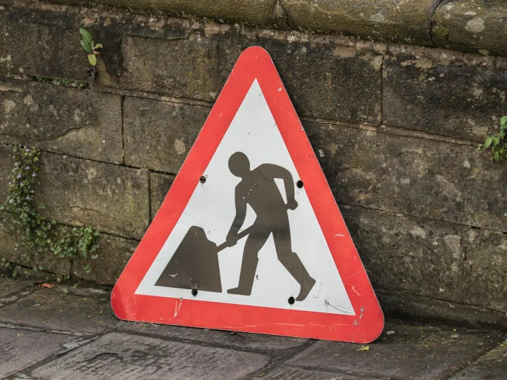 Triangular road work sign placed on a city