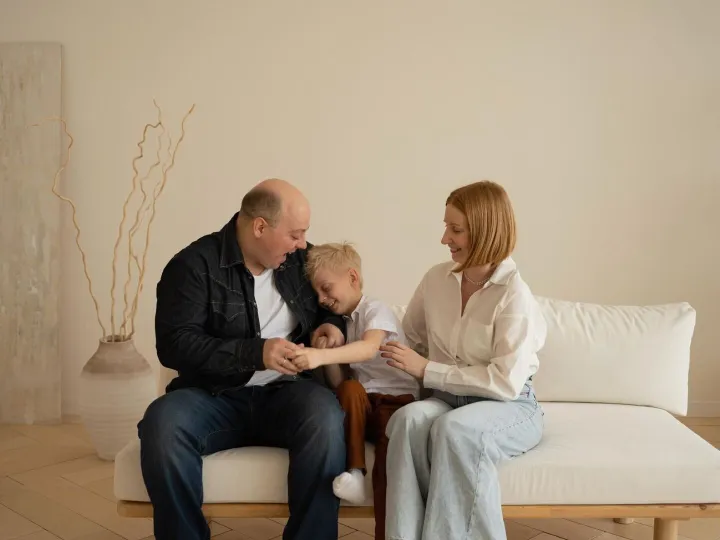 Happy family sitting on sofa in living room Father mother an