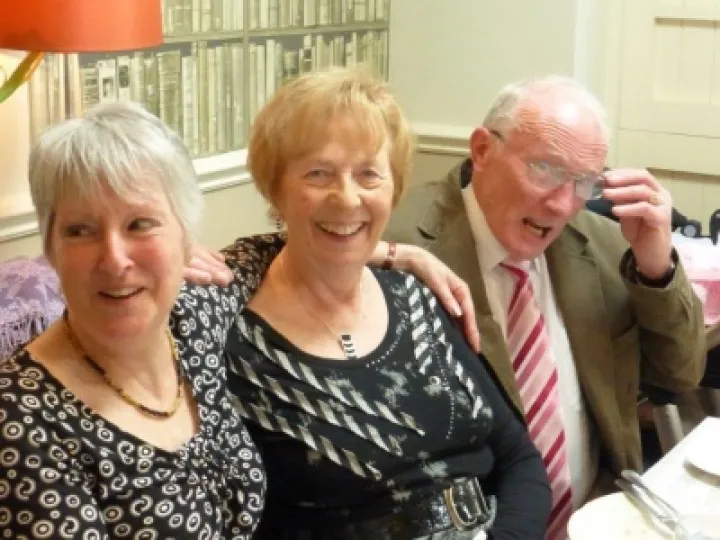 Roland Hall on knees with two ladies