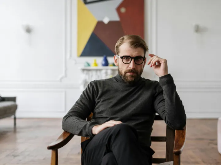 Man in Black Sweater Sitting on Brown Wooden Chair
