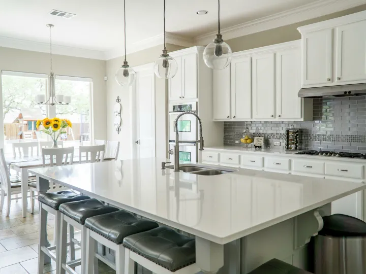 Spacious modern kitchen with white cabinets and island in natural light.