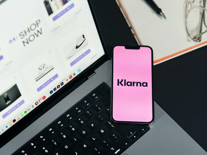Laptop and smartphone displaying online shopping and Klarna for convenient e-commerce.