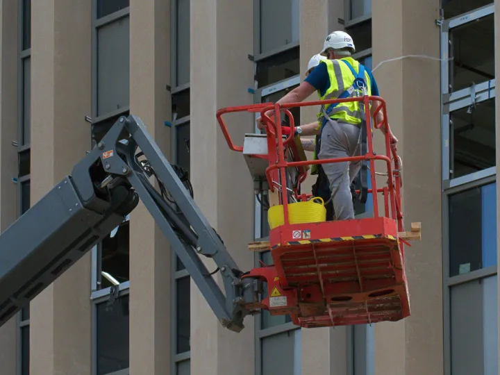 Worker painting on a cherry picker
