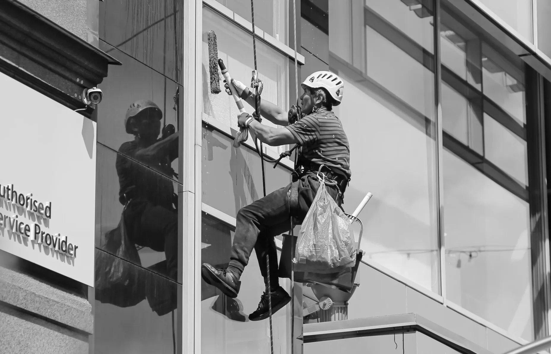 Professional window cleaner working on a