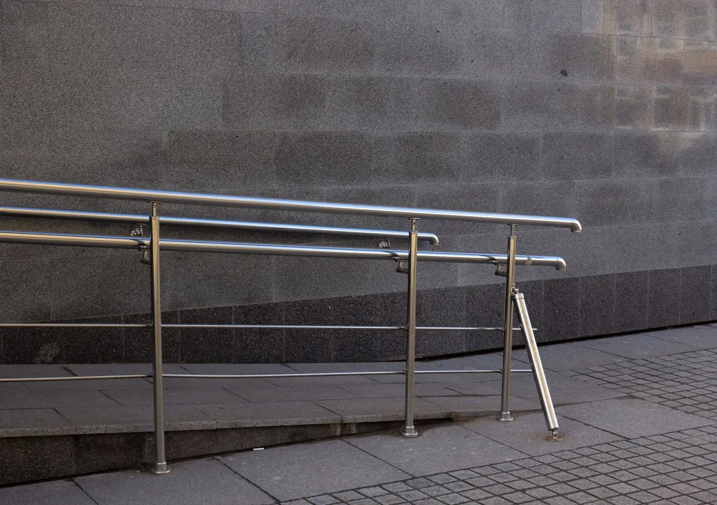 Close-up of a metal handrail and concrete ramp