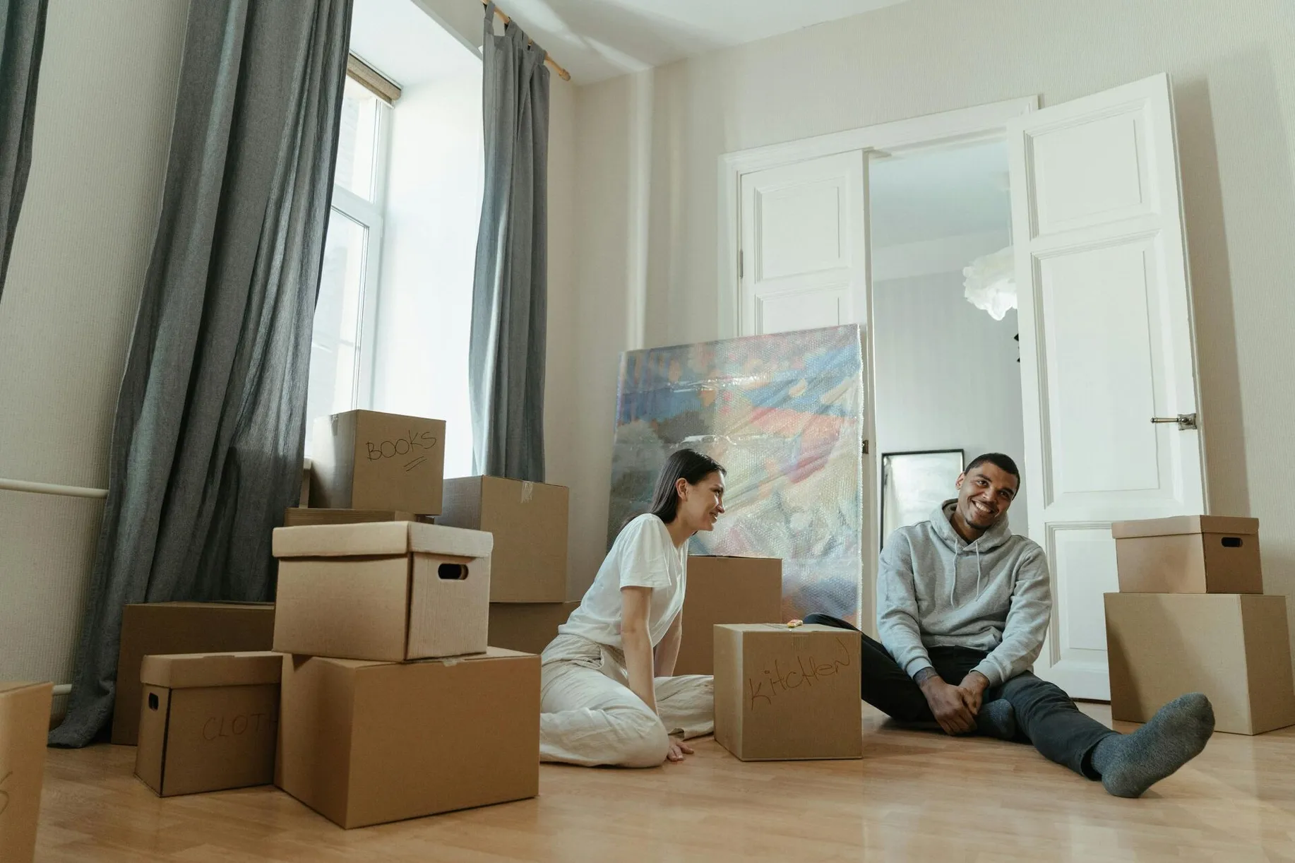 A happy couple surrounded by boxes while moving