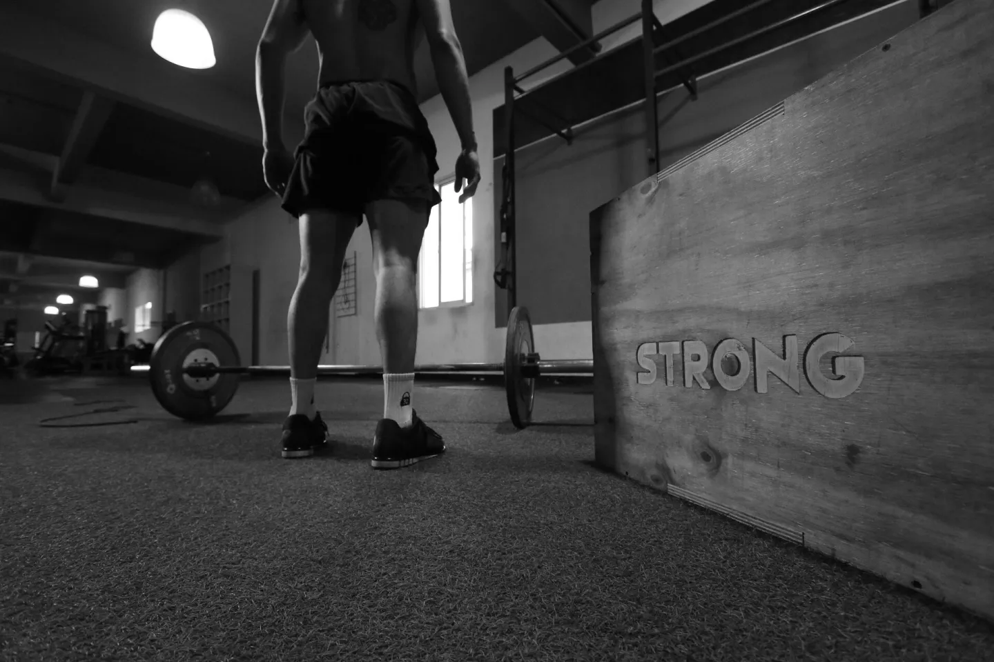 Black and white photo of a man in a gym with