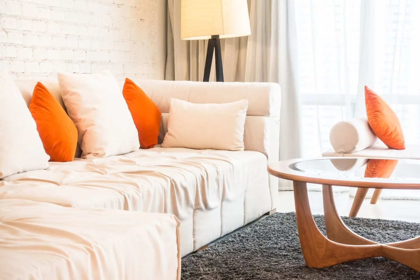 Large couch with cushions and glass table