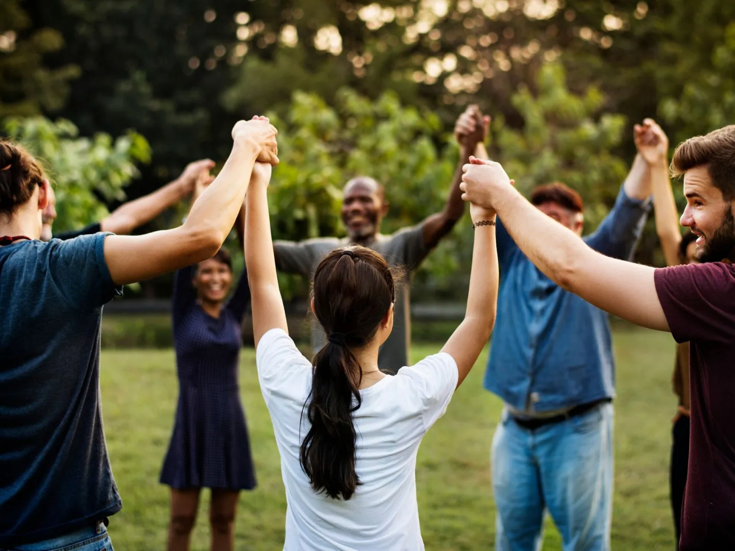 Group of people holding hand together in the park