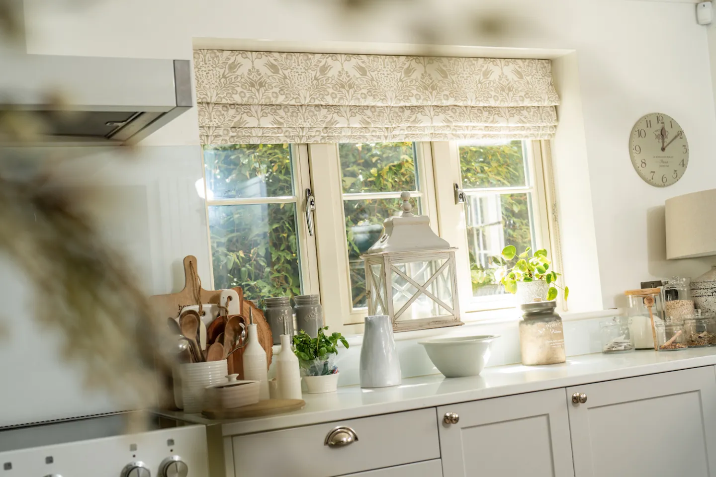 Patterned roman blinds in cream and white kitchen
