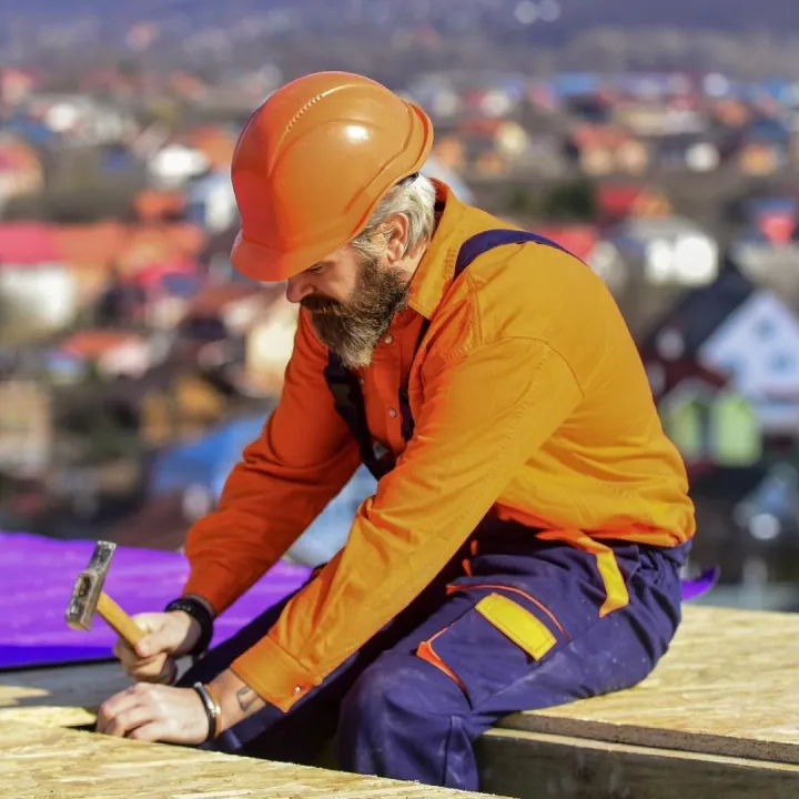 Roofer worker in special protective work wear new roof under