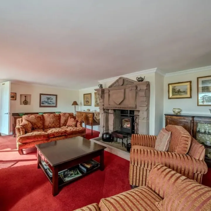 The lounge with sofas around the 18th century fireplace and log burner