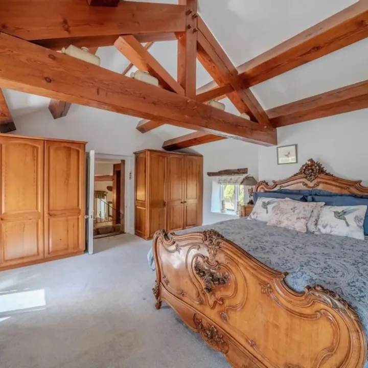 Bedroom one, a beamed room with a large French bed