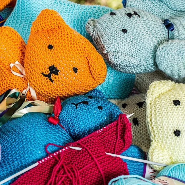 Hand-knitted woollen figures with knitting needles and balls of wool