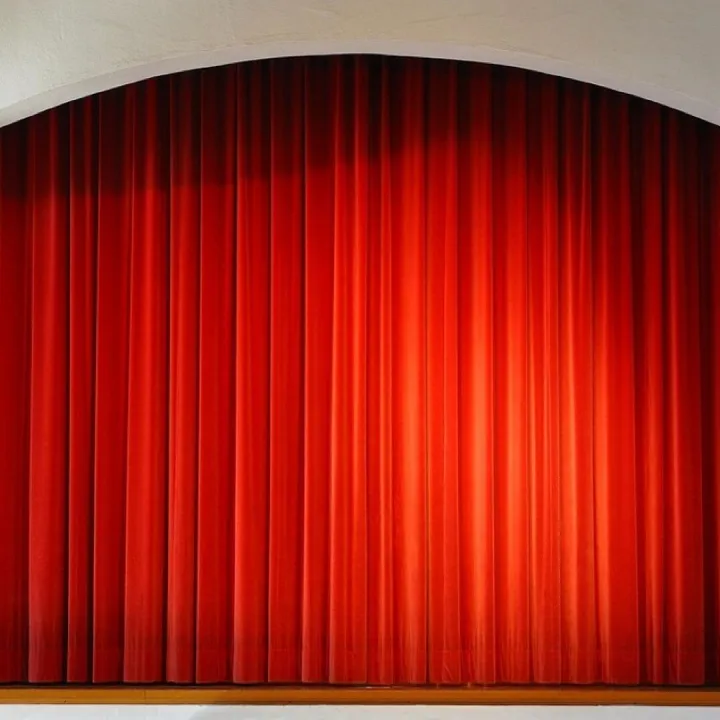 Red curtains drawn across a small church hall stage