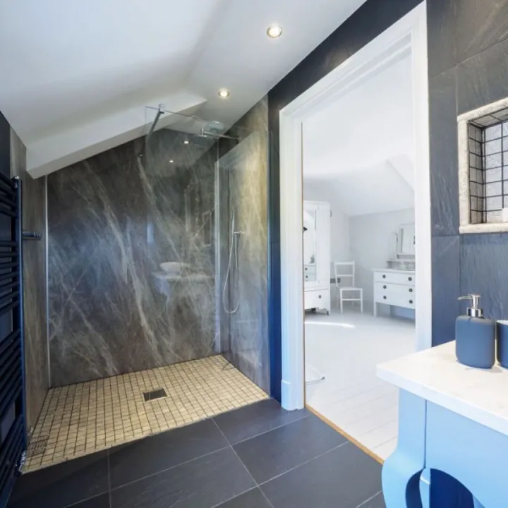 The grey tiled en suite wet room to bedroom two at Otters Retreat