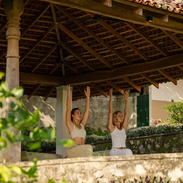 Guests practising yoga in the open ambalama at Peacock Hill Sigiriya