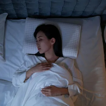 Calm and peaceful woman resting in bed under dim