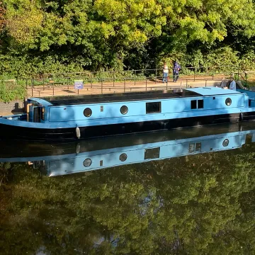 Blue solar-powered boat moored up on a canal