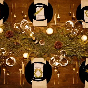 Elegant Christmas dinner table with candles, pine