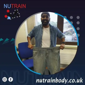 Male Client Holding Oversized Jeans After Weight Loss