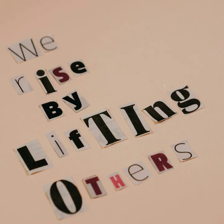 Cutout letters forming an inspirational quote on a beige background, encouraging positivity.