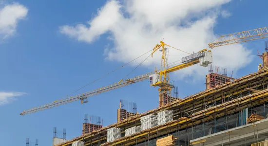 A modern construction site with cranes against a