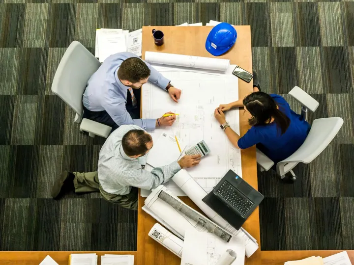 Top view of a team working on construction plans